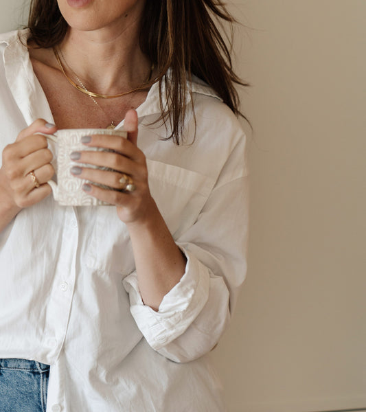 a woman holding a cup of coffee